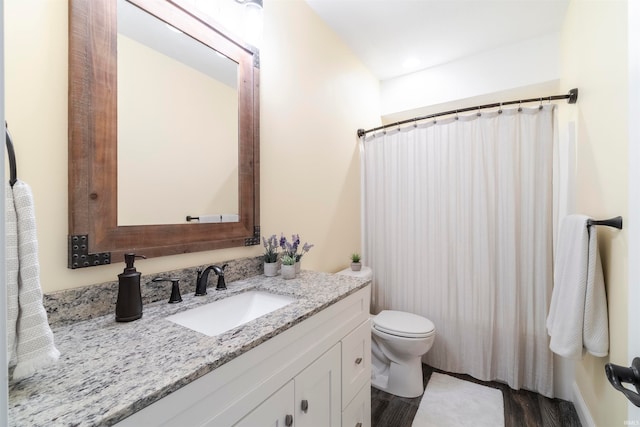 bathroom with vanity, toilet, hardwood / wood-style flooring, and walk in shower