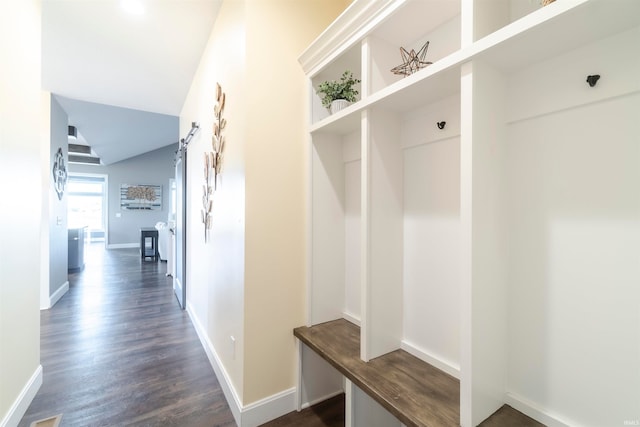 mudroom with dark wood-type flooring and a barn door