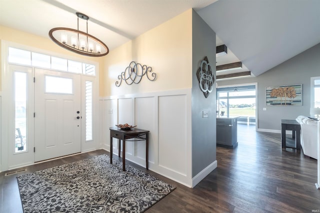 entrance foyer featuring lofted ceiling, a chandelier, and dark wood-type flooring