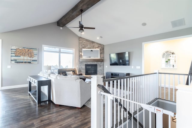 living room featuring ceiling fan, a fireplace, vaulted ceiling with beams, and dark hardwood / wood-style floors