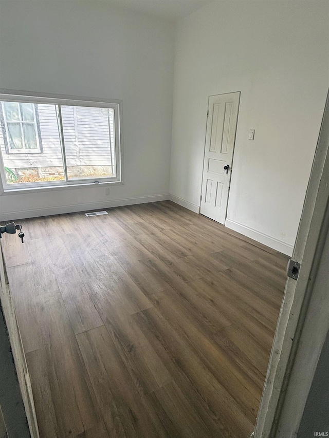 spare room featuring dark wood-type flooring