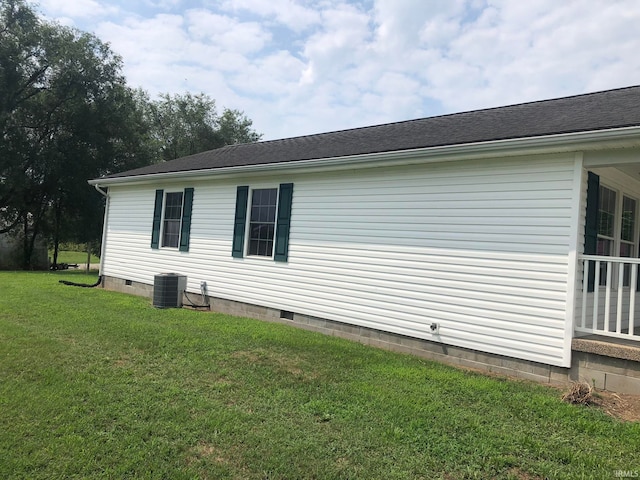 view of side of home with central air condition unit and a lawn