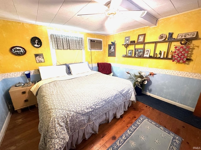 bedroom with a wall unit AC, ceiling fan, and dark hardwood / wood-style floors