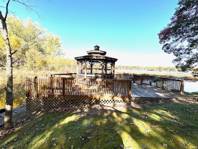 view of dock with a gazebo, a deck with water view, and a yard