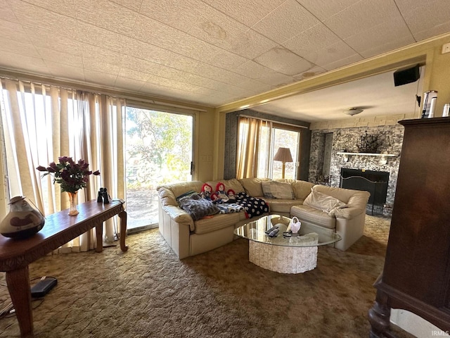 living room with carpet and a stone fireplace