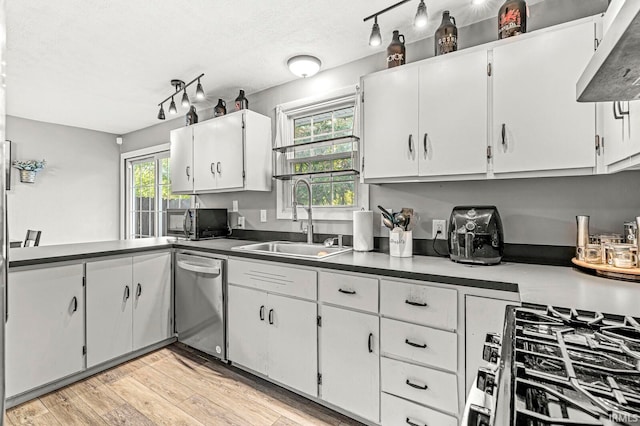 kitchen featuring white cabinets, appliances with stainless steel finishes, a textured ceiling, light wood-type flooring, and sink