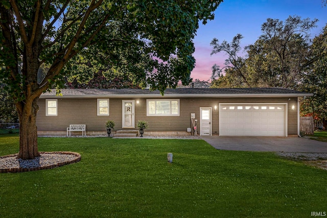 ranch-style home featuring a lawn and a garage