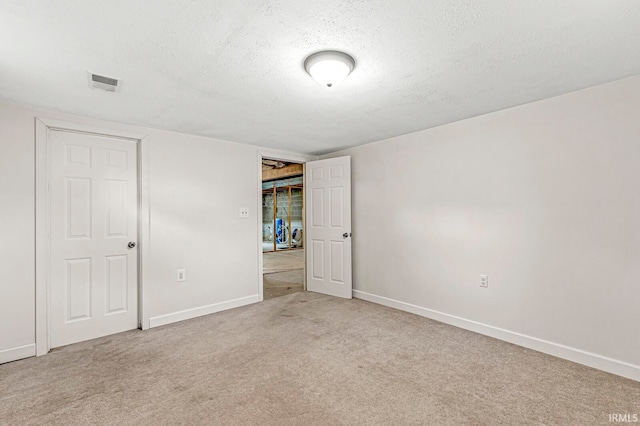 unfurnished bedroom featuring light carpet and a textured ceiling