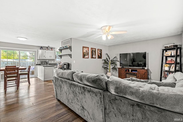 living room with ceiling fan, hardwood / wood-style flooring, and a textured ceiling