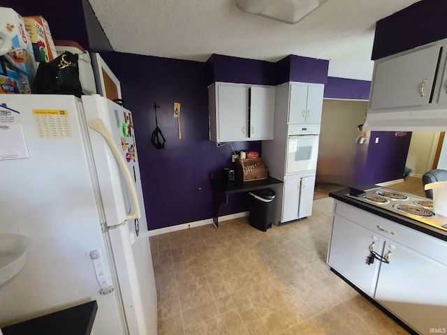 kitchen featuring white cabinetry and white appliances