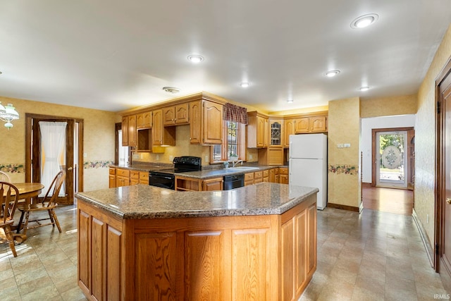 kitchen with a center island, black appliances, sink, and plenty of natural light