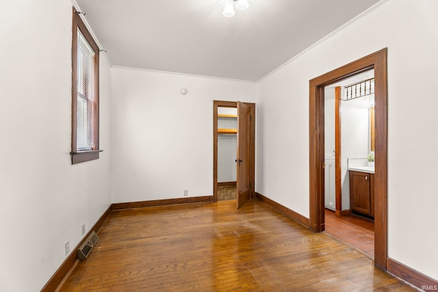 unfurnished bedroom featuring crown molding and wood-type flooring