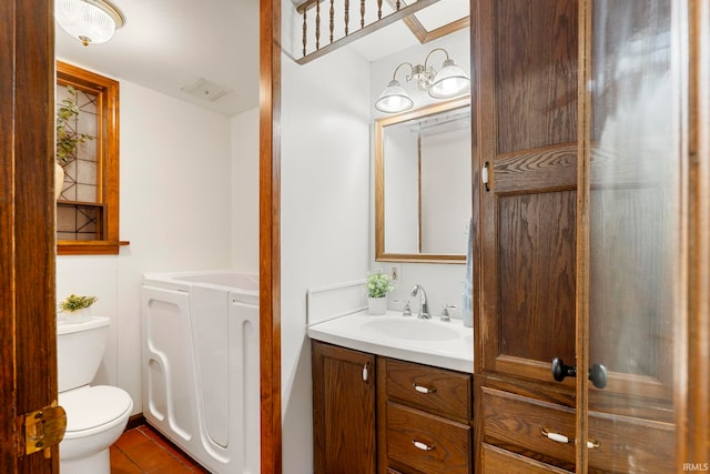 bathroom featuring toilet, vanity, tile patterned floors, and washer and clothes dryer