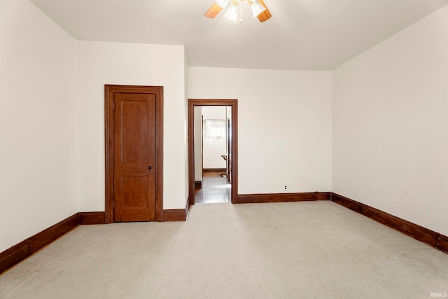 empty room with ceiling fan and light colored carpet