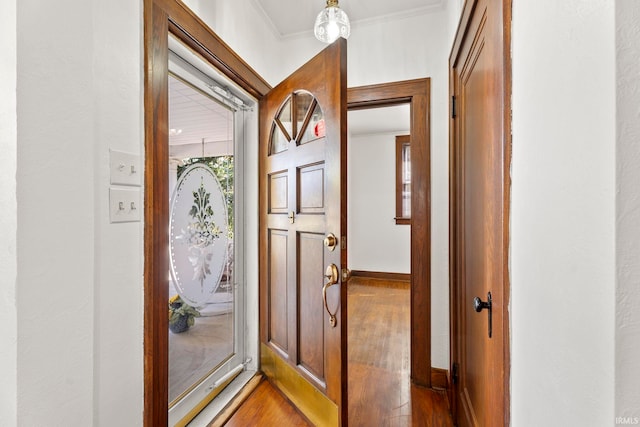 doorway to outside featuring crown molding and hardwood / wood-style flooring