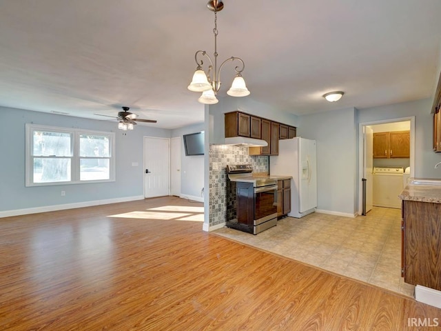 kitchen featuring washer / clothes dryer, white refrigerator with ice dispenser, electric range, pendant lighting, and light hardwood / wood-style flooring