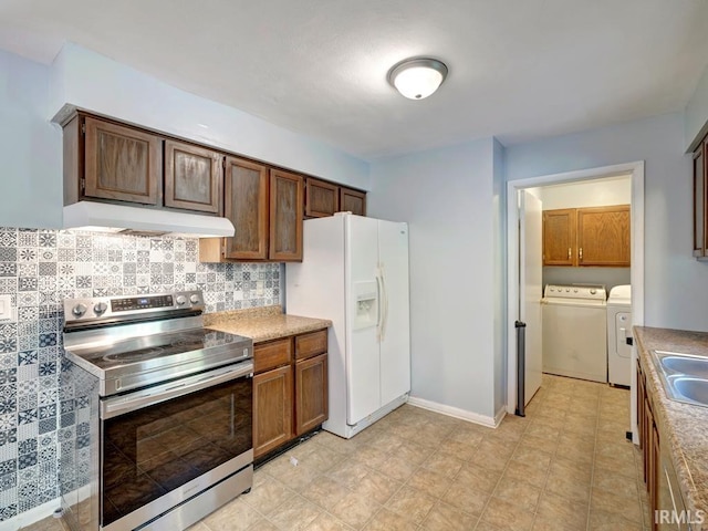 kitchen with decorative backsplash, washer and clothes dryer, stainless steel range with electric stovetop, sink, and white refrigerator with ice dispenser