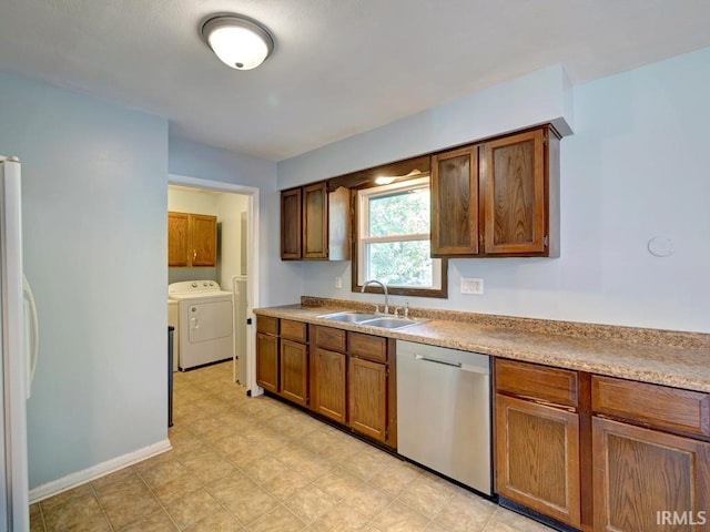 kitchen featuring washer and dryer, dishwasher, sink, and white refrigerator