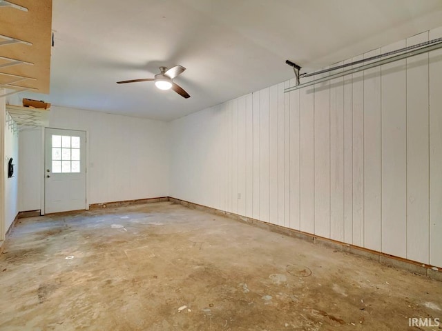 interior space featuring wood walls and ceiling fan