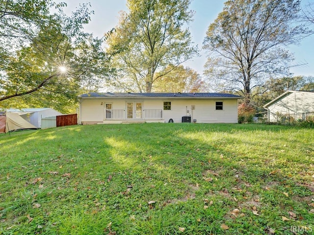 rear view of property with french doors, a yard, and cooling unit