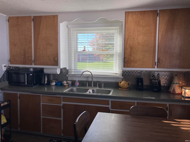 kitchen featuring a textured ceiling, tasteful backsplash, and sink