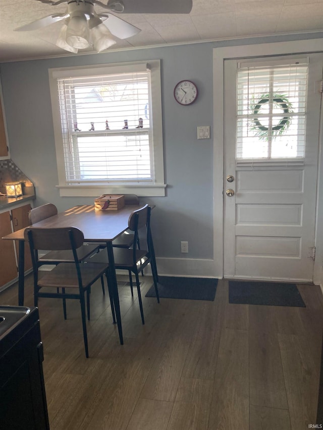 dining space with dark wood-type flooring, ceiling fan, and a healthy amount of sunlight