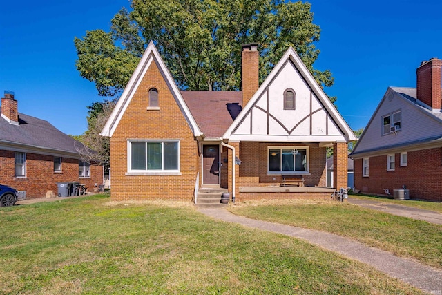 tudor home with a front lawn and central AC unit