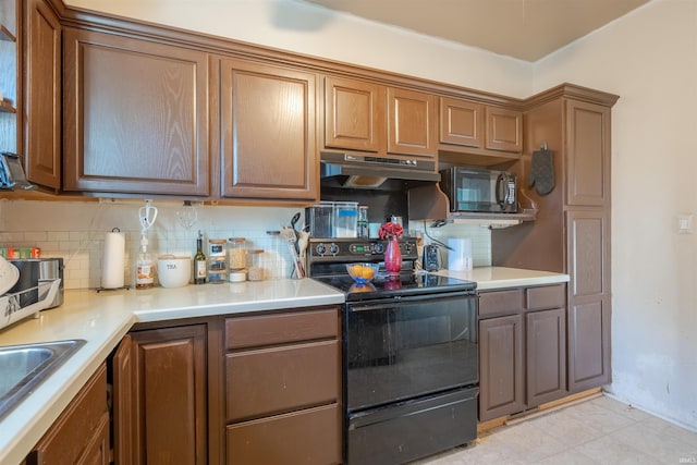 kitchen featuring black appliances, sink, and backsplash