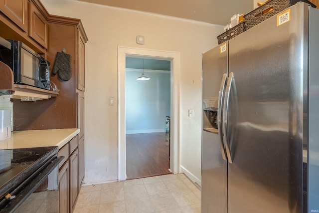 kitchen featuring black appliances, crown molding, and light wood-type flooring