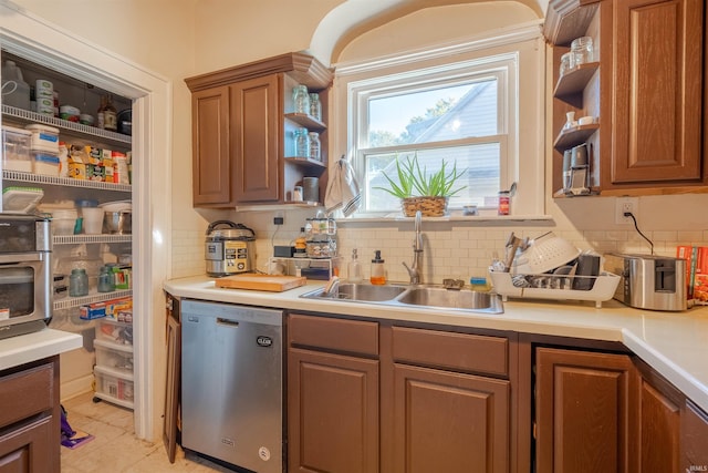 kitchen featuring sink, light tile patterned floors, dishwasher, and backsplash