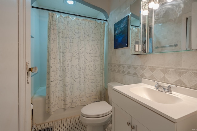 full bathroom with shower / bath combo, toilet, tile patterned floors, tile walls, and vanity