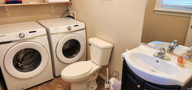 bathroom with vanity, washer and clothes dryer, and toilet