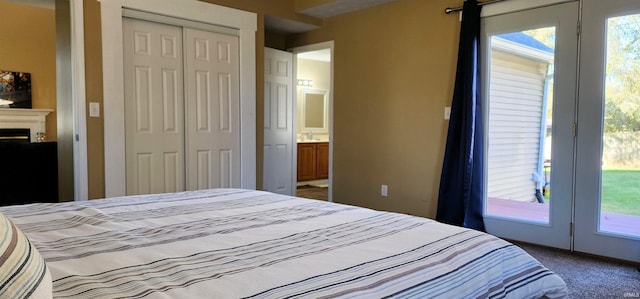 carpeted bedroom featuring a closet, connected bathroom, and access to outside