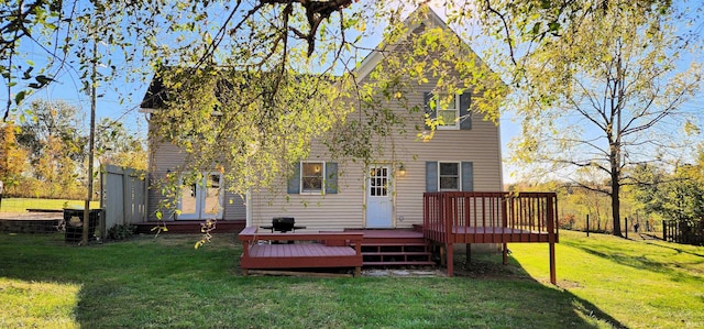 back of house featuring a wooden deck and a lawn