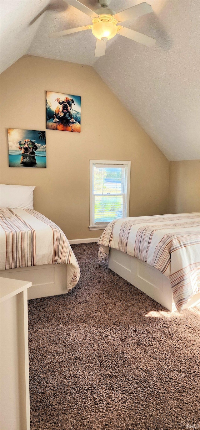 bedroom featuring lofted ceiling, a textured ceiling, carpet flooring, and ceiling fan