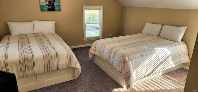 bedroom with lofted ceiling and dark colored carpet