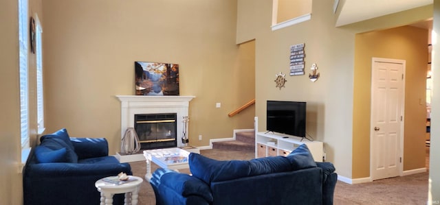 living room with a high ceiling, carpet flooring, and plenty of natural light