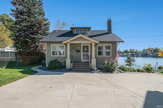 bungalow-style home featuring a front lawn and a water view