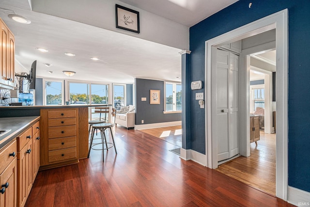 kitchen with a breakfast bar and dark hardwood / wood-style flooring