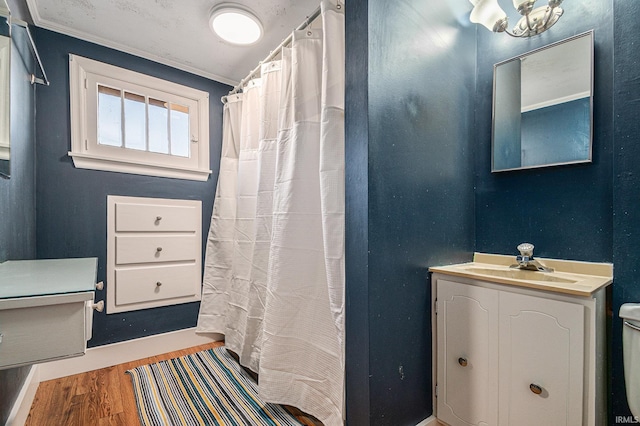 bathroom featuring vanity, ornamental molding, hardwood / wood-style flooring, and walk in shower