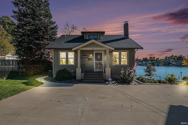 bungalow-style home with central air condition unit and a water view