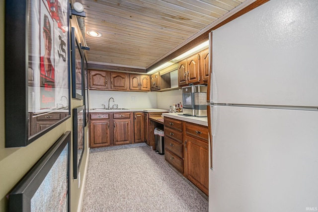 kitchen with wood ceiling, ornamental molding, sink, light colored carpet, and white refrigerator