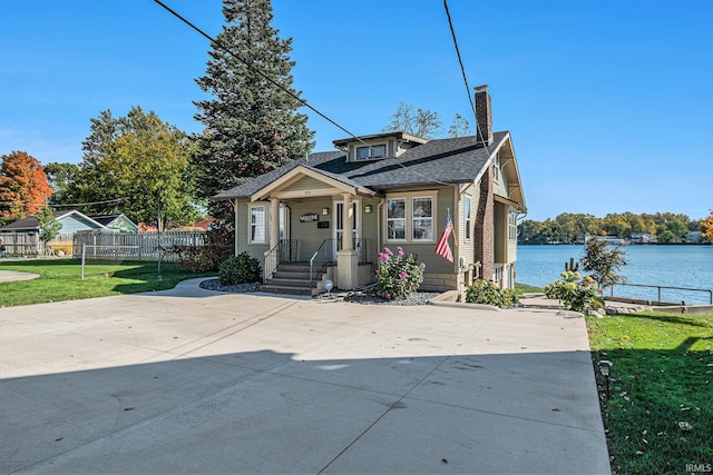 bungalow-style house featuring a front yard, a water view, and a porch