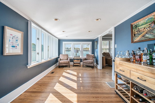 sitting room with light hardwood / wood-style flooring and crown molding