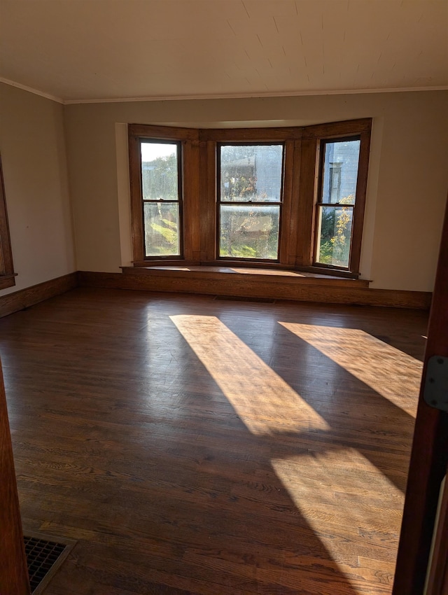 spare room with crown molding and dark hardwood / wood-style floors