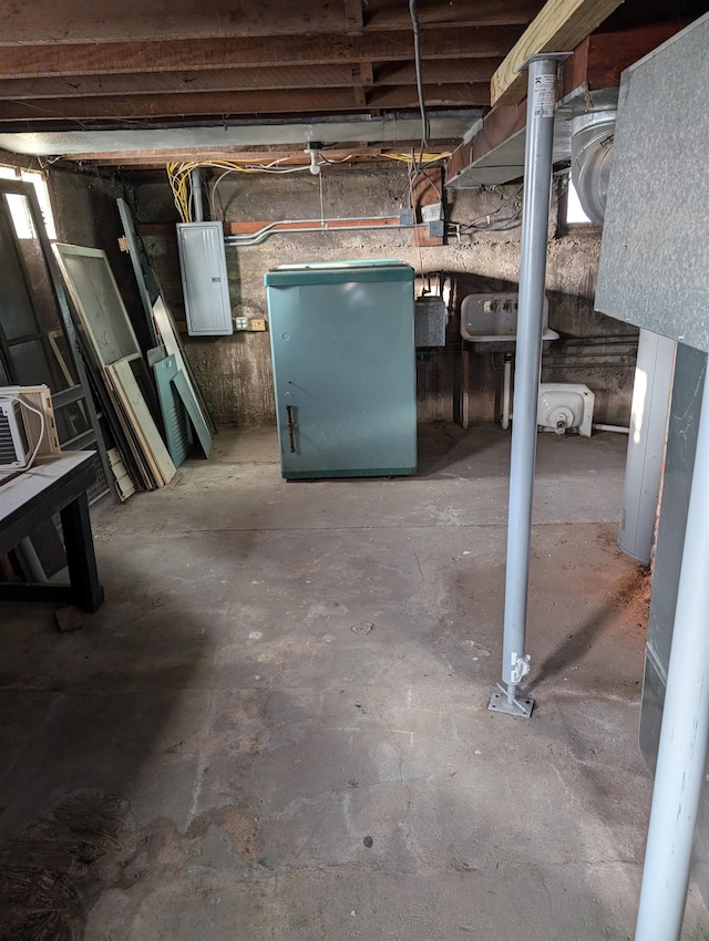 basement featuring refrigerator and electric panel