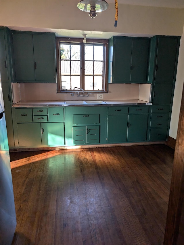 kitchen featuring dark hardwood / wood-style floors, green cabinets, and sink