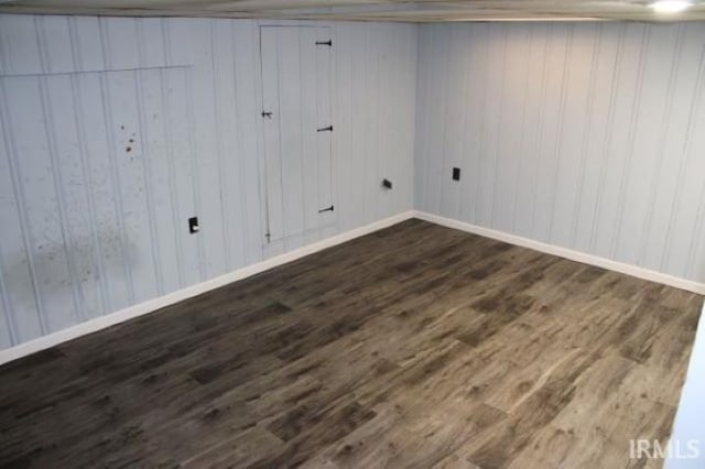 interior space with wood walls and dark hardwood / wood-style flooring