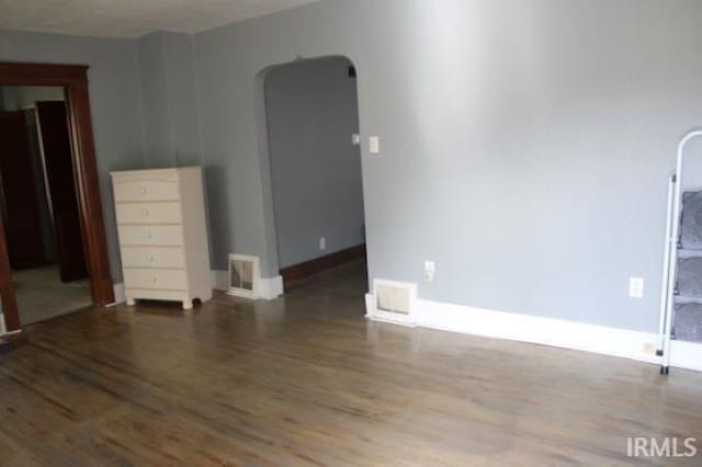 empty room with dark wood-type flooring and a textured ceiling