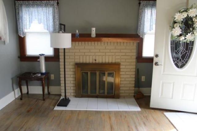 living room with a wealth of natural light, a fireplace, and hardwood / wood-style flooring